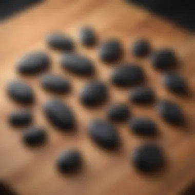 A collection of black obsidian worry stones arranged artfully on a wooden surface, highlighting their natural beauty.