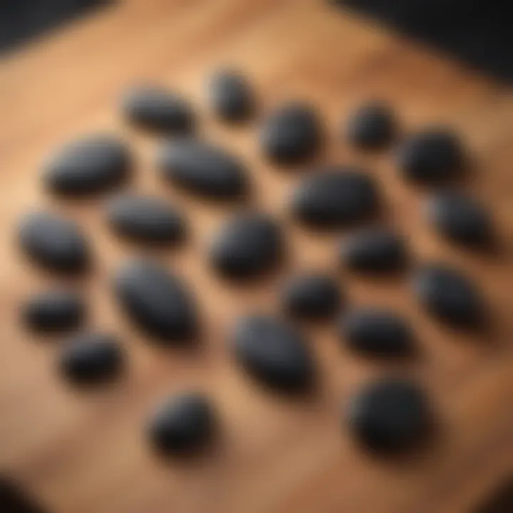 A collection of black obsidian worry stones arranged artfully on a wooden surface, highlighting their natural beauty.