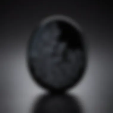 Close-up view of a polished black obsidian worry stone showcasing its glossy surface and intricate patterns.